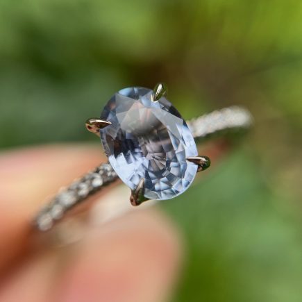 18ct white gold and oval blue sapphire engagement ring with diamond-set shoulders