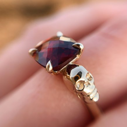 9ct yellow gold and Garnet double-skull ring