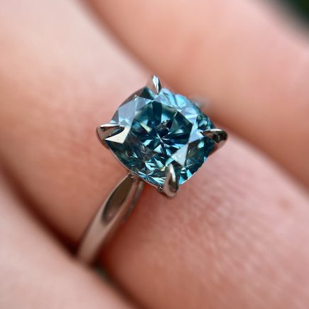 Platinum and cushion-cut treated blue diamond engagement ring