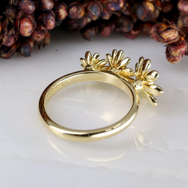18ct yellow gold and emerald daisy trilogy ring