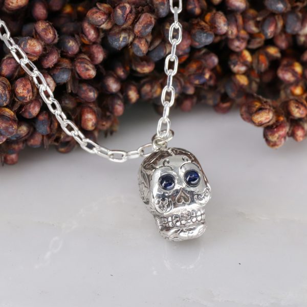 Silver sugar skull pendant set with blue sapphire eyes