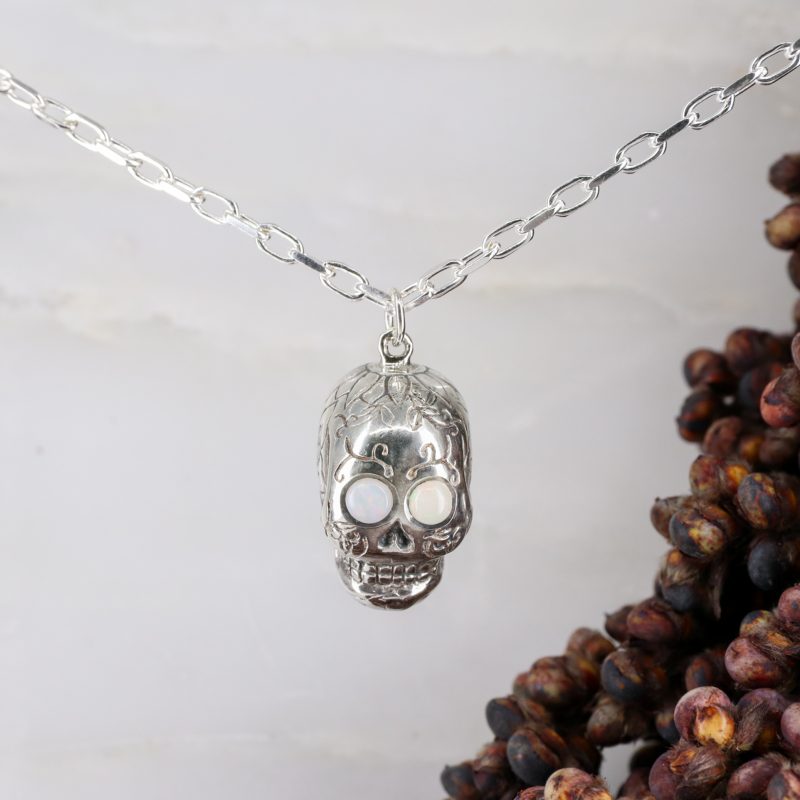 Silver sugar skull pendant set with opal eyes