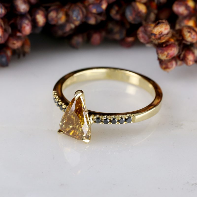 18ct yellow gold orange diamond rise ring with black diamond shoulders
