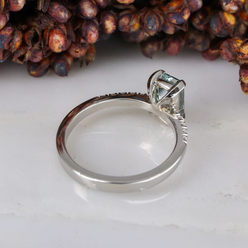 Platinum emerald cut blue diamond rise ring with white diamond shoulders