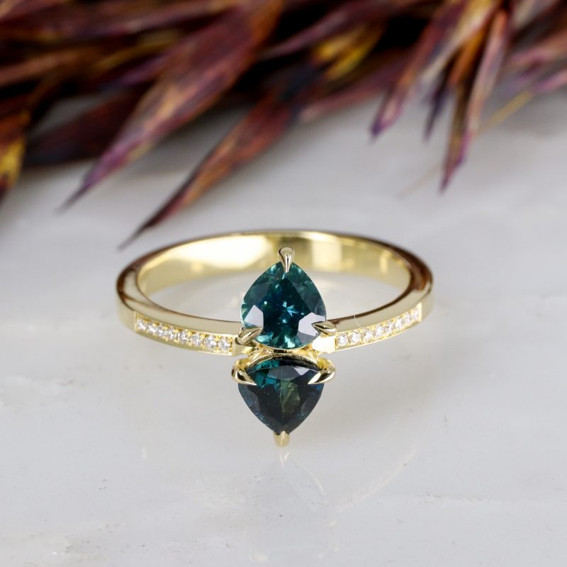 18ct yellow gold teal sapphire toi et moi ring with grain set diamond shoulders