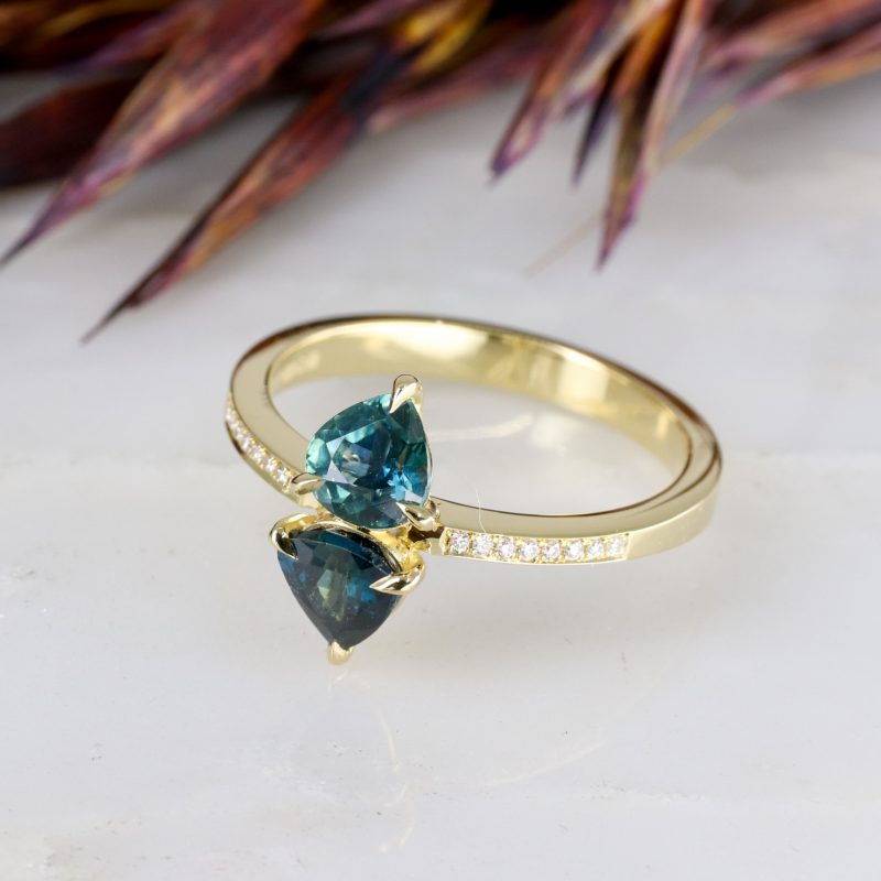 18ct yellow gold teal sapphire toi et moi ring with grain set diamond shoulders