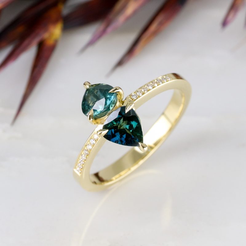 18ct yellow gold teal sapphire toi et moi ring with grain set diamond shoulders