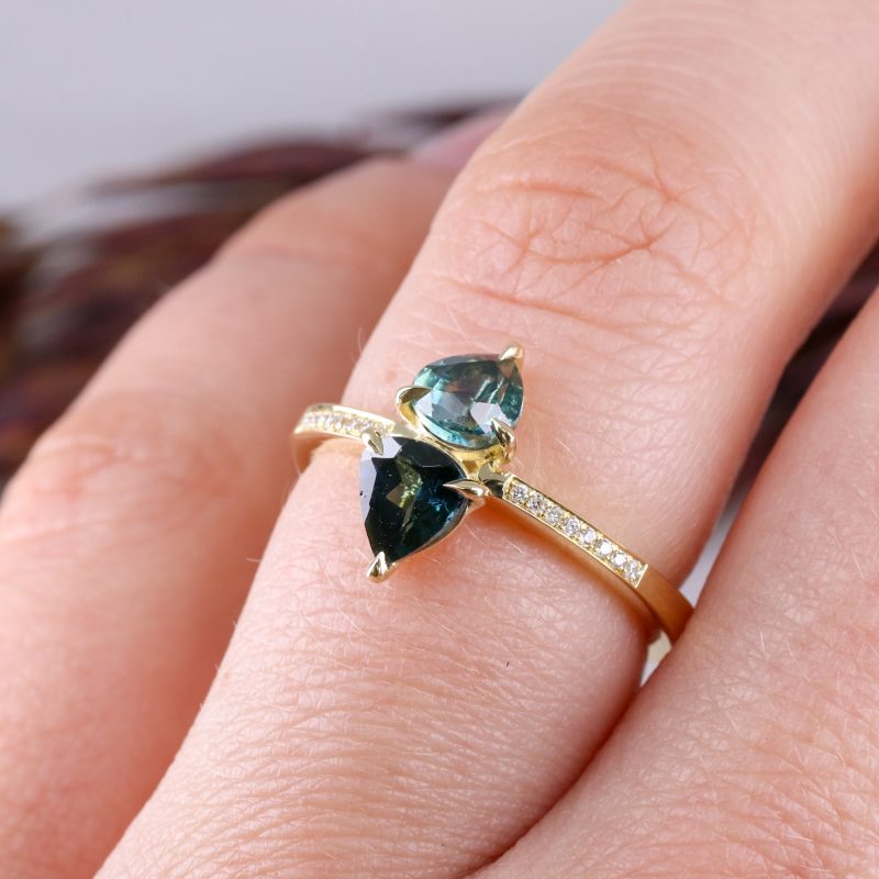18ct yellow gold teal sapphire toi et moi ring with grain set diamond shoulders