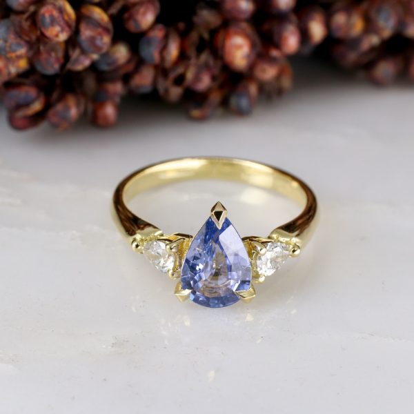 18ct yellow gold pear shape blue sapphire trilogy ring with pear shape salt and pepper diamond shoulders