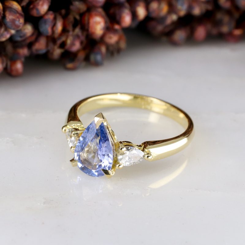 18ct yellow gold pear shape blue sapphire trilogy ring with pear shape salt and pepper diamond shoulders