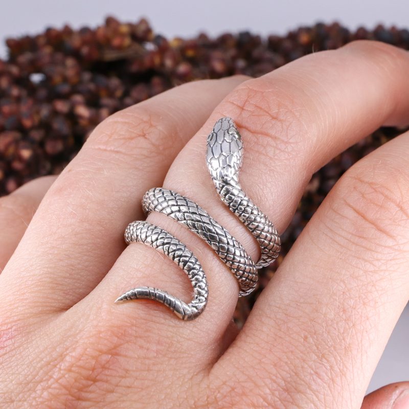 Silver coiled snake ring with emerald eyes
