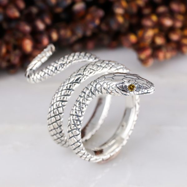 Silver coiled snake ring with orange diamond eyes