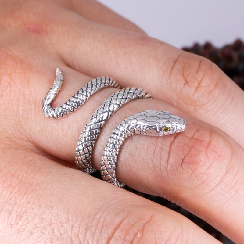 Silver coiled snake ring with orange diamond eyes