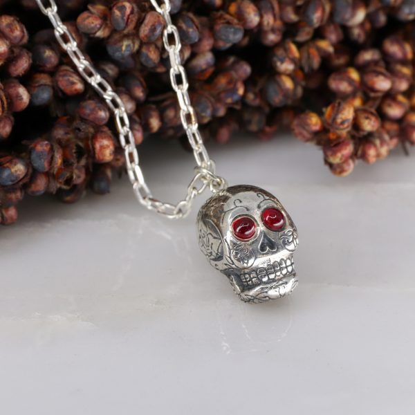 Silver sugar skull pendant set with ruby eyes