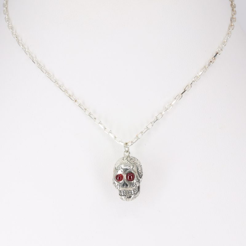 Silver sugar skull pendant set with ruby eyes