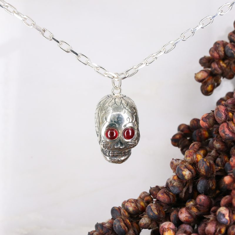 Silver sugar skull pendant set with ruby eyes