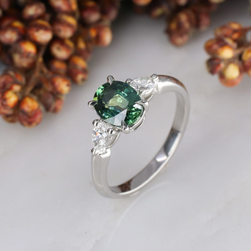 Platinum oval teal sapphire and diamond trilogy ring